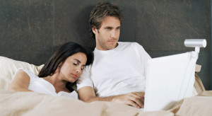 Man using laptop in bed